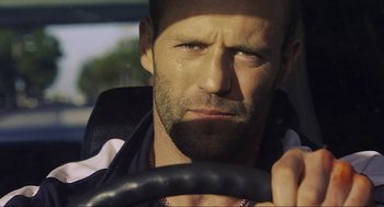Movie still from “Crank” (2006), directed by Mark Neveldine – A person driving a car; Close Up shot, Over the shoulder angle