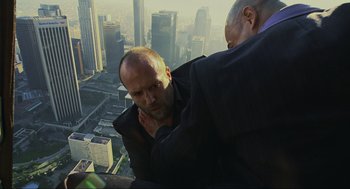 Movie still from “Crank” (2006), directed by Mark Neveldine – Two men standing on the side of a skyscraper; Medium shot, Overhead angle