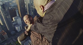 Movie still from “Crank” (2006), directed by Mark Neveldine – Two men in business suits fighting on a skyscraper; Medium shot, Overhead angle