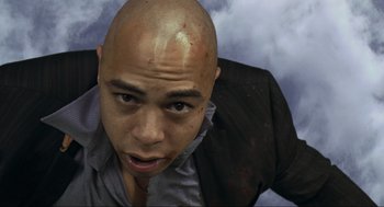 Movie still from “Crank” (2006), directed by Mark Neveldine – A man with a shaved head and a black shirt; Close Up shot, Overhead angle