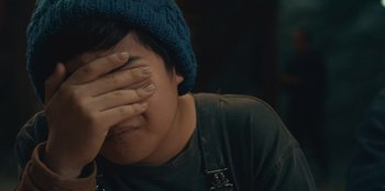Movie still from “Crater” (2023), directed by Kyle Patrick Alvarez – A person with a hat covering their face; Close Up shot, Over the shoulder angle