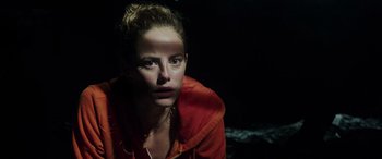 Movie still from “Crawl” (2019), directed by Alexandre Aja – A woman in an orange jacket is looking at the camera; Close Up shot, High angle