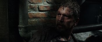 Movie still from “Crawl” (2019), directed by Alexandre Aja – A person wearing a shirt near a brick wall; Close Up shot, Over the shoulder angle
