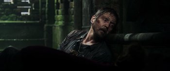 Movie still from “Crawl” (2019), directed by Alexandre Aja – A man sitting in a dark room with his eyes closed; Close Up shot, Over the shoulder angle
