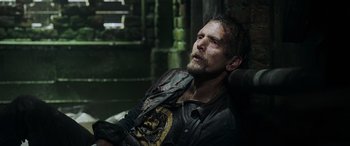 Movie still from “Crawl” (2019), directed by Alexandre Aja – A man sitting in a chair with his eyes closed; Medium shot, Low angle