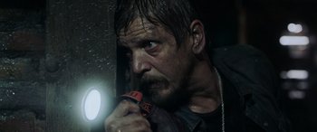 Movie still from “Crawl” (2019), directed by Alexandre Aja – A person holding a flashlight; Close Up shot, Low angle