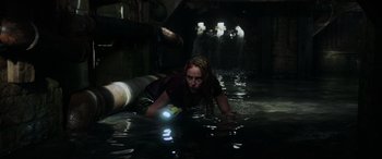 Movie still from “Crawl” (2019), directed by Alexandre Aja – A woman in the water holding a flashlight; Medium shot, High angle