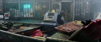 Movie still from “Crawl” (2019), directed by Alexandre Aja – A man standing in the rain next to an atm machine; Wide shot, High angle