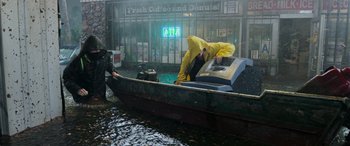 Movie still from “Crawl” (2019), directed by Alexandre Aja – A man in a yellow raincoat is in a small boat; Wide shot, High angle