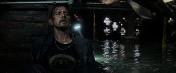 Movie still from “Crawl” (2019), directed by Alexandre Aja – A man in a black shirt is in a body of water at night; Medium shot, Over the shoulder angle