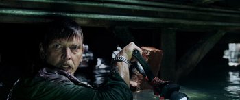 Movie still from “Crawl” (2019), directed by Alexandre Aja – A man holding a wrench in his hand; Close Up shot, Low angle