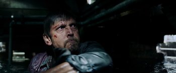 Movie still from “Crawl” (2019), directed by Alexandre Aja – A person holding a gun in a dark room; Close Up shot, Over the shoulder angle