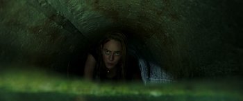 Movie still from “Crawl” (2019), directed by Alexandre Aja – A woman with green eyes looking out of a tunnel; Close Up shot, Low angle