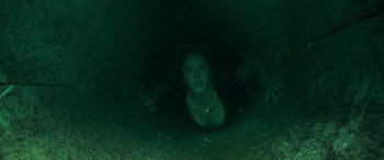 Movie still from “Crawl” (2019), directed by Alexandre Aja – A woman in a dark cave looking up at the camera; Medium shot, Overhead angle