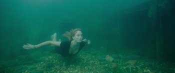 Movie still from “Crawl” (2019), directed by Alexandre Aja – A woman swimming underwater in a body of water; Wide shot, High angle