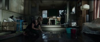 Movie still from “Crawl” (2019), directed by Alexandre Aja – A woman in a black shirt is painting a floor; Wide shot, High angle