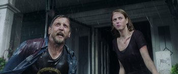 Movie still from “Crawl” (2019), directed by Alexandre Aja – A man and a woman standing next to each other in the rain; Medium shot, Low angle