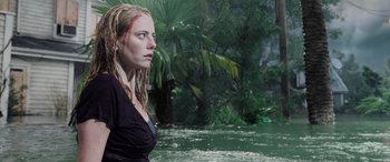 Movie still from “Crawl” (2019), directed by Alexandre Aja – A woman in a black shirt standing next to a body of water; Medium shot, Over the shoulder angle