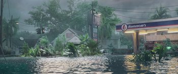 Movie still from “Crawl” (2019), directed by Alexandre Aja – A flooded area with a gas station sign and a car; Extreme Wide shot, High angle