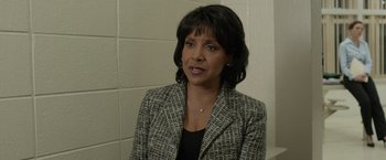 Movie still from “Creed” (2015), directed by Ryan Coogler – A woman wearing a suit and a necklace; Close Up shot, Over the shoulder angle