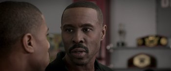 Movie still from “Creed” (2015), directed by Ryan Coogler – A person wearing a black shirt; Close Up shot, Over the shoulder angle