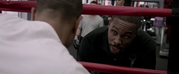 Movie still from “Creed” (2015), directed by Ryan Coogler – A man looking at himself in the mirror in a boxing ring; Close Up shot, Over the shoulder angle