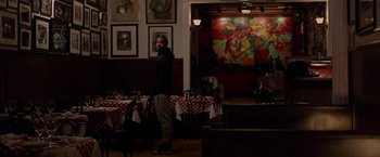 Movie still from “Creed” (2015), directed by Ryan Coogler – A man standing in front of a table in a restaurant; Wide shot, Low angle