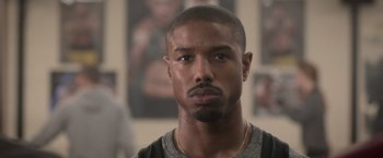 Movie still from “Creed” (2015), directed by Ryan Coogler – A man's face in front of a picture; Close Up shot, Over the shoulder angle