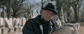 Movie still from “Creed” (2015), directed by Ryan Coogler – A man sitting in front of a bunch of tombstones; Close Up shot, Over the shoulder angle