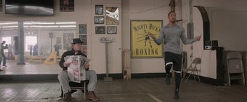 Movie still from “Creed” (2015), directed by Ryan Coogler – A man is jumping in the air in a boxing gym; Wide shot, Over the shoulder angle
