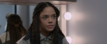 Movie still from “Creed” (2015), directed by Ryan Coogler – A young woman with long braids looking at the camera; Close Up shot, Over the shoulder angle