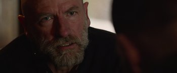 Movie still from “Creed” (2015), directed by Ryan Coogler – An older man with a beard looking at the camera; Close Up shot, Over the shoulder angle