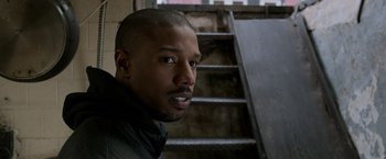 Movie still from “Creed” (2015), directed by Ryan Coogler – A person near a stair railing; Close Up shot, Over the shoulder angle