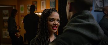 Movie still from “Creed” (2015), directed by Ryan Coogler – A woman with long braids smiles at the camera; Close Up shot, Over the shoulder angle
