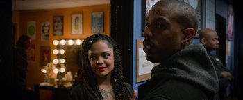 Movie still from “Creed” (2015), directed by Ryan Coogler – A man standing next to a woman in front of a wall; Close Up shot, Over the shoulder angle