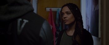 Movie still from “Creed” (2015), directed by Ryan Coogler – A young woman with long braids standing in front of a mirror; Close Up shot, Over the shoulder angle