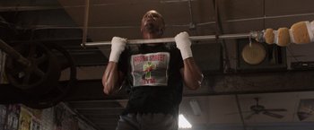 Movie still from “Creed” (2015), directed by Ryan Coogler – A man is doing pull - ups in a gym; Close Up shot, Low angle