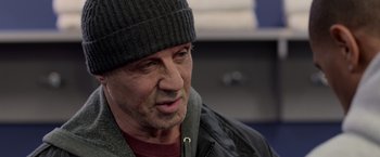 Movie still from “Creed” (2015), directed by Ryan Coogler – A person wearing a hat and jacket; Close Up shot, Over the shoulder angle
