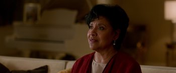 Movie still from “Creed” (2015), directed by Ryan Coogler – An older woman sitting on a couch in a living room; Close Up shot, Over the shoulder angle