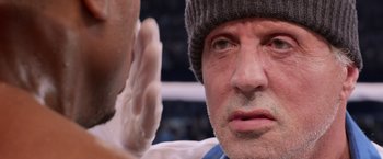 Movie still from “Creed” (2015), directed by Ryan Coogler – A person wearing a hat; Close Up shot, Over the shoulder angle