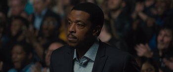 Movie still from “Creed II” (2018), directed by Steven Caple Jr. – A man in a suit and tie; Close Up shot, Over the shoulder angle