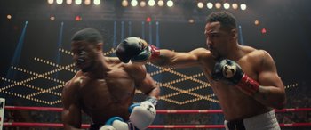 Movie still from “Creed II” (2018), directed by Steven Caple Jr. – Two boxers in a boxing ring during a match; Medium shot, Over the shoulder angle
