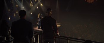 Movie still from “Creed II” (2018), directed by Steven Caple Jr. – A man standing on a balcony in front of an audience; Wide shot, Over the shoulder angle