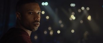 Movie still from “Creed II” (2018), directed by Steven Caple Jr. – A man's face in front of lights at night; Close Up shot, Low angle