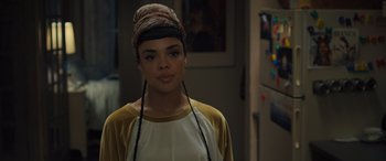Movie still from “Creed II” (2018), directed by Steven Caple Jr. – A young woman wearing a hat with braids on her head; Close Up shot, Over the shoulder angle