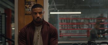 Movie still from “Creed II” (2018), directed by Steven Caple Jr. – A person wearing a jacket; Close Up shot, Over the shoulder angle