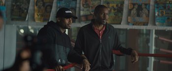 Movie still from “Creed II” (2018), directed by Steven Caple Jr. – Two young men sitting next to each other in a room; Medium shot, High angle