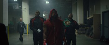 Movie still from “Creed II” (2018), directed by Steven Caple Jr. – A group of men standing next to each other in a hallway; Medium shot, Low angle
