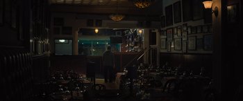 Movie still from “Creed II” (2018), directed by Steven Caple Jr. – A person standing in a room near a table; Wide shot, Low angle