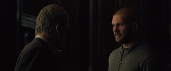 Movie still from “Creed II” (2018), directed by Steven Caple Jr. – A man standing next to another man in a dark room; Close Up shot, Over the shoulder angle